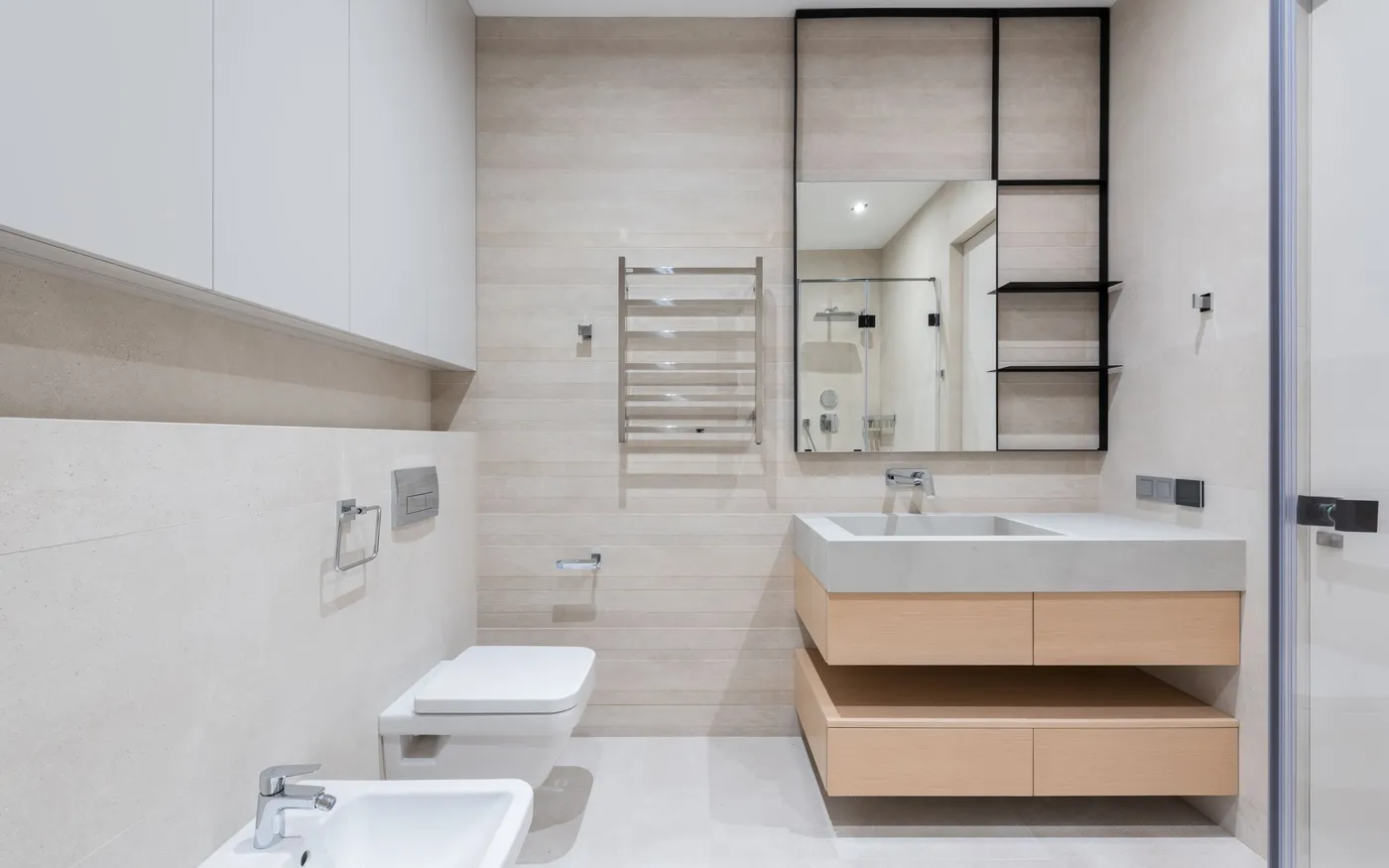 Banyo boy dolabı modelleri; ahşap desenli asma lavabo altı dolabı, üstte beyaz kapaklı dolaplar ve siyah çerçeveli ayna