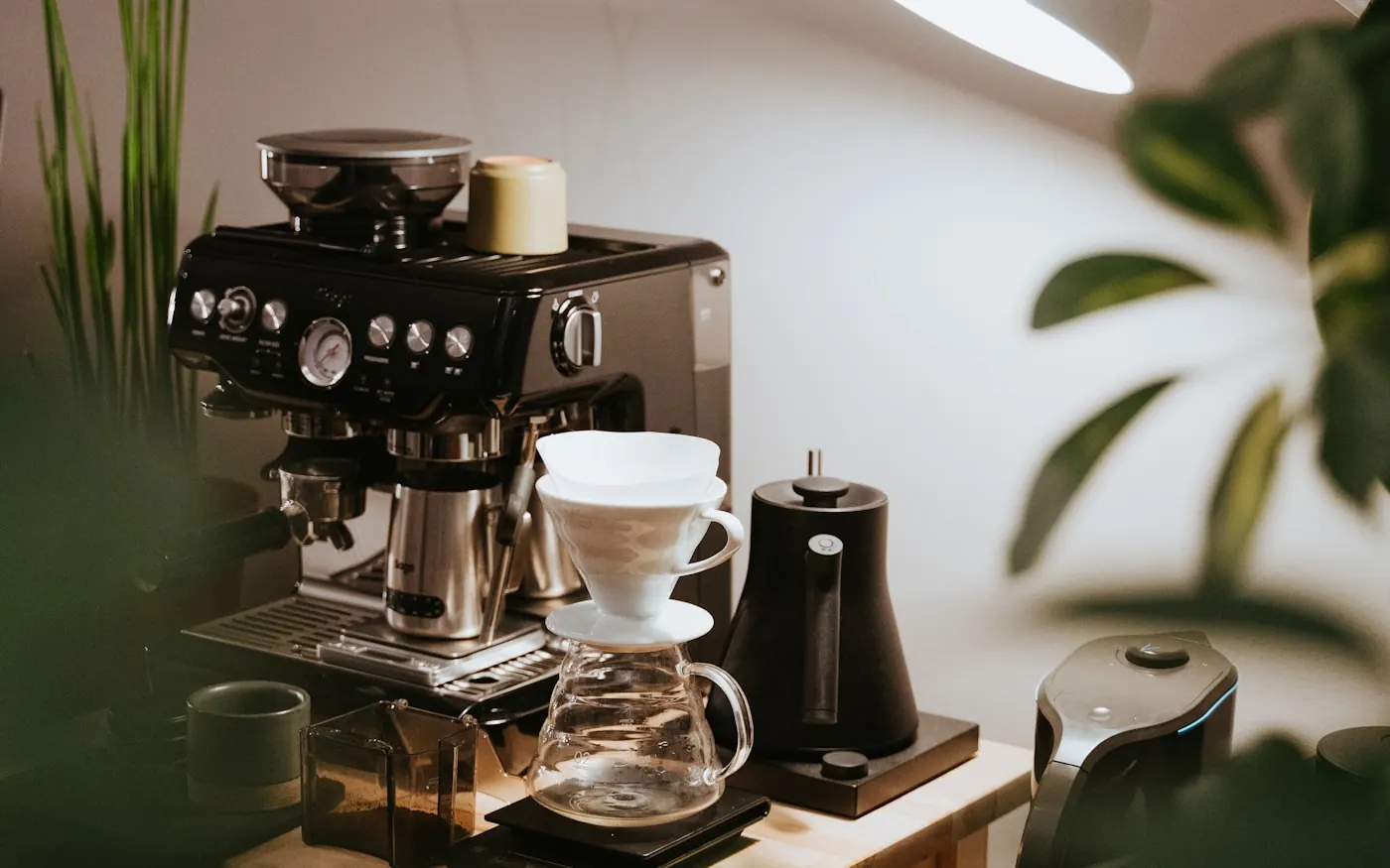 Ev içinde ahşap tezgah üzerinde kurulmuş kahve köşesi ve espresso makinesi